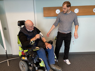 Mann erklärt Rollstuhlfahrer einen Sensor