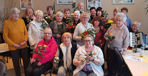 Gruppe von Frauen mit Blumensträußen. 