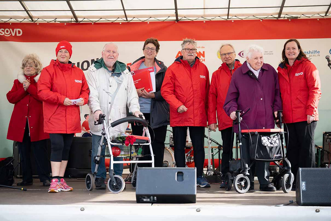 Sieben Personen nebeneinander auf der Bühne. 