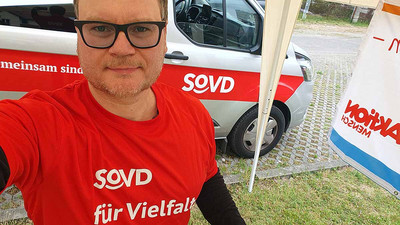 Mann mit SoVD-Shirt vor dem Sozialmobil