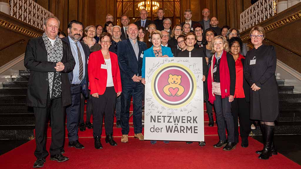 Menschengruppe mit Plakat "Netzwerk der Wärme"