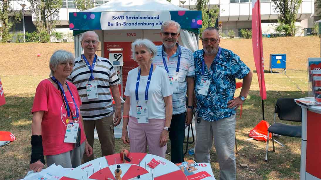 Fünf Personen an einem Infostand