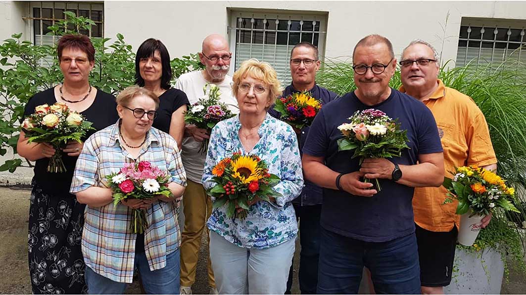 Männer und Frauen mit Blumensträußen in der Hand